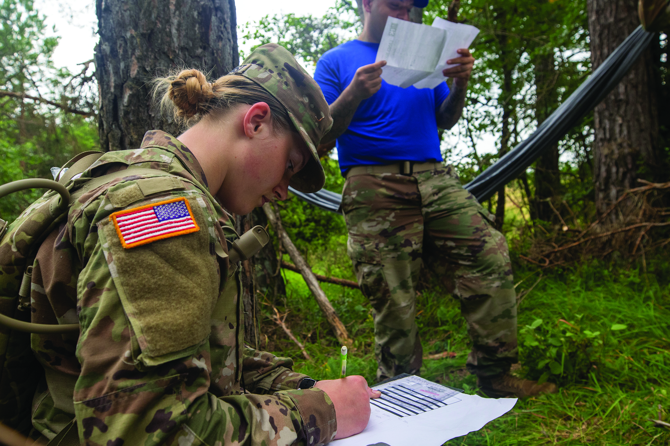 PFC Shania Woodhurst, paralegal specialist, 30th Medical Brigade, receives grid coordinates during the land navigation event on day two of the USAREUR Best
        Warrior Competition at U.S. Army Garrison Hohenfels Training Area, Germany, in July 2020. (Credit: SPC Kaden D. Pitt)